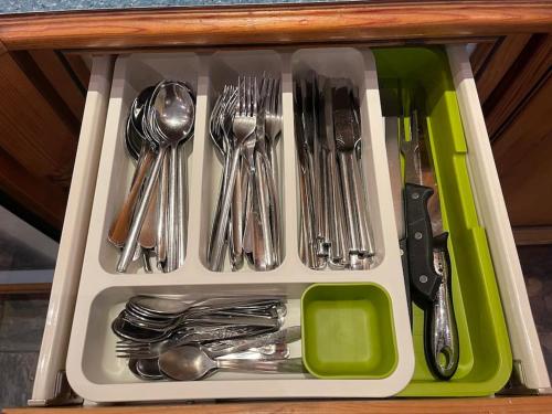 a drawer filled with silver utensils on a table at Ballinderry Station Cottage - Beautiful Holiday Cottage in Ballinderry Upper