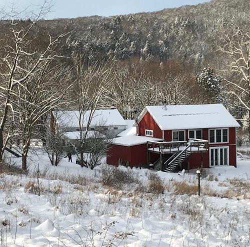 a red barn covered in snow in a field at the barn at gallatin farmstead in Red Hook