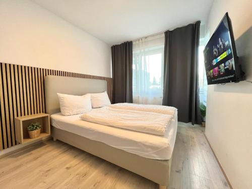 a bedroom with a bed with a flat screen tv at Apartment Leverkusen in Leverkusen