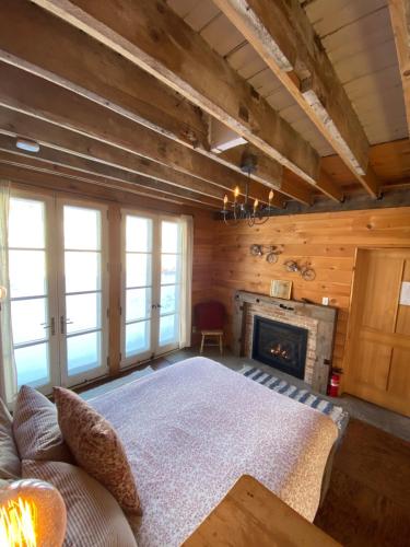 a living room with a bed and a fireplace at the barn at gallatin farmstead in Red Hook