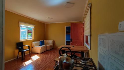 a kitchen and living room with a stove and a couch at Cabaña entre rios in Villarrica