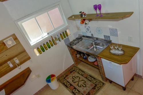 uma pequena cozinha com um lavatório e uma janela em Verde Vida Ecopousada - Termas do Gravatal em Gravatal