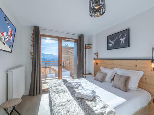 a bedroom with a large bed and a balcony at Appartement lumineux avec parking, proche des pistes à Alpe d'Huez - FR-1-645-62 in LʼHuez