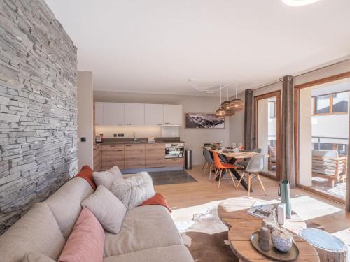 un salon avec un canapé et un mur de briques dans l'établissement Charmant appartement 3 pièces proche des pistes avec balcon, cuisine équipée et garage à l'Alpe d'Huez. - FR-1-645-52, à Huez