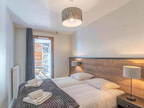 a bedroom with a large bed with two towels on it at Appartement Alpe d'Huez 4 adultes+2 enfants avec parking et WiFi - FR-1-645-66 in LʼHuez