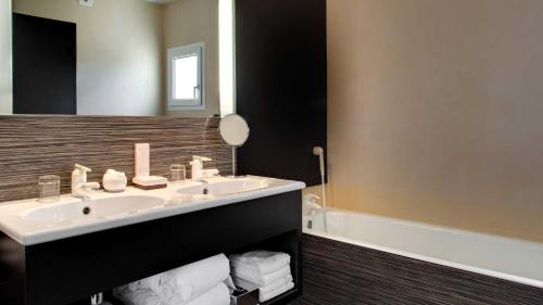 La salle de bains est pourvue d'un lavabo et d'un miroir. dans l'établissement Le Sénéchal, à Sauveterre-de-Rouergue