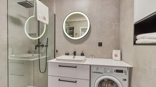 a bathroom with a washing machine and a sink at Rezydencja Niechorze 219 - 5D Apartamenty in Niechorze