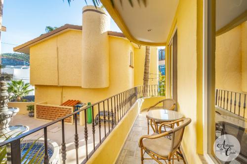 a balcony with a table and chairs and a building at Antigua de Cabo in Cabo San Lucas