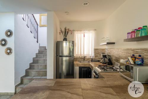 a kitchen with a stainless steel refrigerator and stairs at Antigua de Cabo in Cabo San Lucas