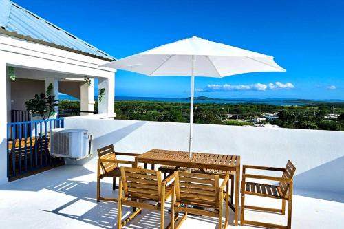 un tavolo e sedie con ombrellone su un balcone di Private Penthouse Paradise a Ceiba