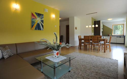 a living room with a couch and a dining room at Ferienwohnungen Leitner-Ebenberger in Greifenburg