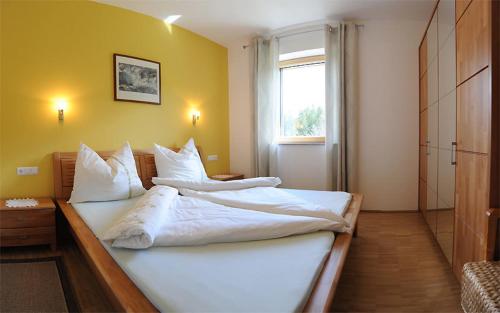 グライフェンブルクにあるFerienwohnungen Leitner-Ebenbergerのベッドルーム1室(大型ベッド1台、白いシーツ、枕付)