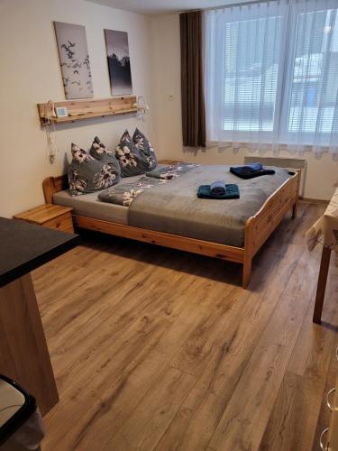 Cama grande en habitación con suelo de madera en Apartmány 009, en Borová Lada