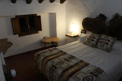 een slaapkamer met een bed en een lamp op een tafel bij Cortijo Wenceslao II 