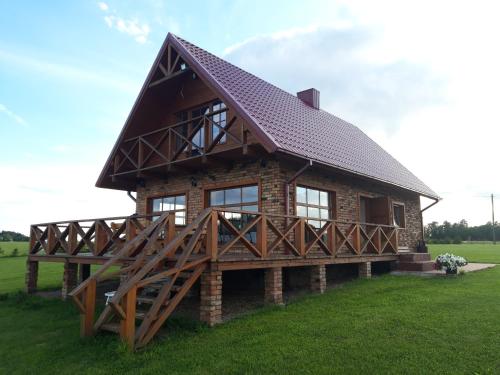 una cabaña de madera con techo de gambrel en Bareišių sodyba, 