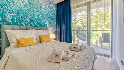 1 dormitorio con 1 cama grande y toallas. en Rezydencja Niechorze 324 - 5D Apartamenty en Niechorze