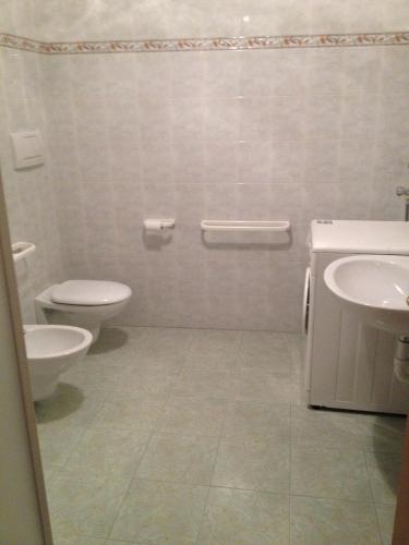 a bathroom with a toilet and a sink at Appartamento Rosa in Coredo