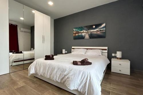 Charming 3-Bed Retreat with Small Pool في سانت جوليانز: غرفة نوم بسرير ابيض كبير عليها مناشف