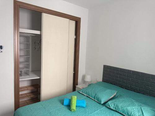 - une chambre avec un lit vert et un miroir dans l'établissement Torremolinos habitaciones privada en apartamentos compartidos, à Torremolinos