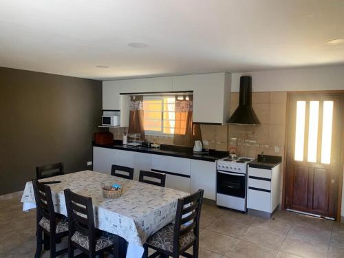 a kitchen with a table and chairs and a kitchen with a stove at La casita de Sue solo para familias reserva solo con seña in Mar del Plata