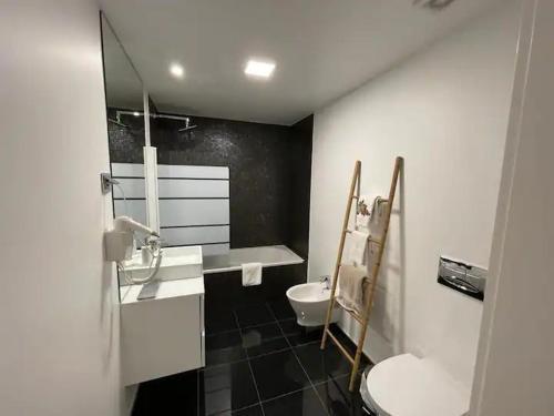 La salle de bains est pourvue de toilettes, d'un lavabo et d'un miroir. dans l'établissement Carreira Residence, à Funchal