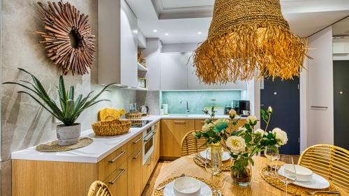 a kitchen with a table with flowers and a chandelier at Rezydencja Niechorze MORSKIE WIDOKI 313 z Basenem i SPA - 5D Apartments in Niechorze