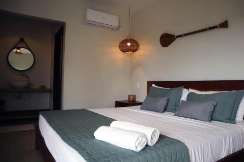 Pousada Vila Camurim في أتينز: غرفة نوم بسرير كبير عليها مناشف