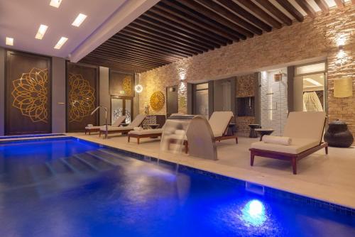 a pool with lounge chairs and a swimming pool at Royalton Hideaway Blue Waters, An Autograph Collection All-Inclusive Resort - Adults Only in Falmouth