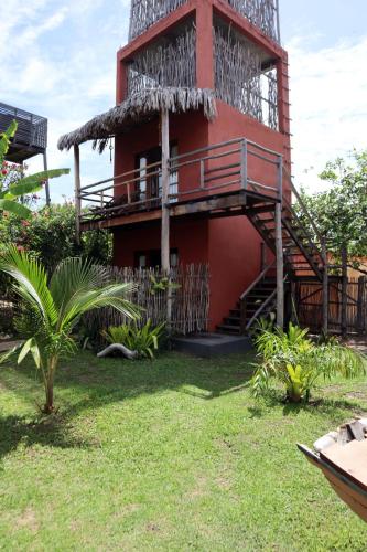 a red building with a staircase and a balcony at Pousada Vila Camurim in Atins