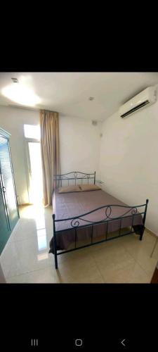 ein Schlafzimmer mit einem Bett in einem Zimmer mit einem Fenster in der Unterkunft Room's Service Swieqi in Tal-Għoqod