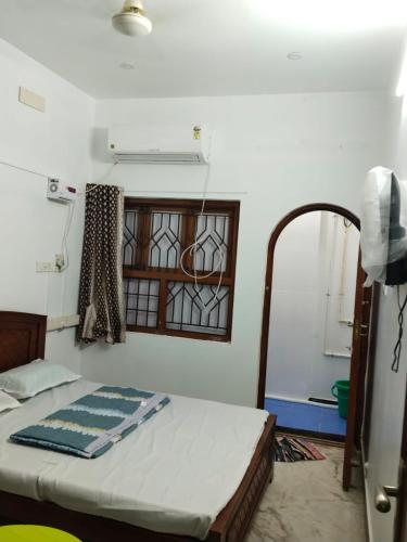 Schlafzimmer mit einem Bett, einem Fenster und einem Spiegel in der Unterkunft Cozy homestay in Puducherry