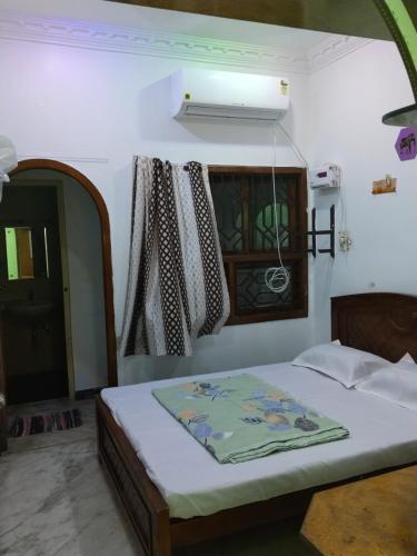Schlafzimmer mit einem Bett und einem Fenster in der Unterkunft Cozy homestay in Puducherry