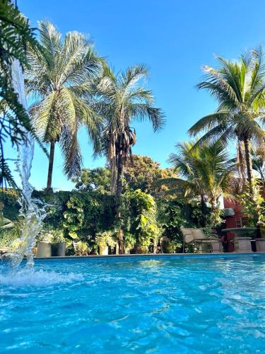 een zwembad met palmbomen op de achtergrond bij HOTEL POUSADA MACHADO in Frutal