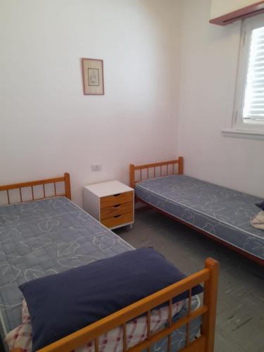 a bedroom with two beds and a table and a window at Depto Miramar in Miramar