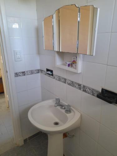 a bathroom with a white sink and a cabinet at Depto Miramar in Miramar
