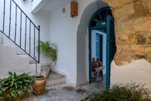 uma casa com uma porta azul e alguns vasos de plantas em GINVA - Vejer de la Frontera & Plaza de España em Vejer de la Frontera