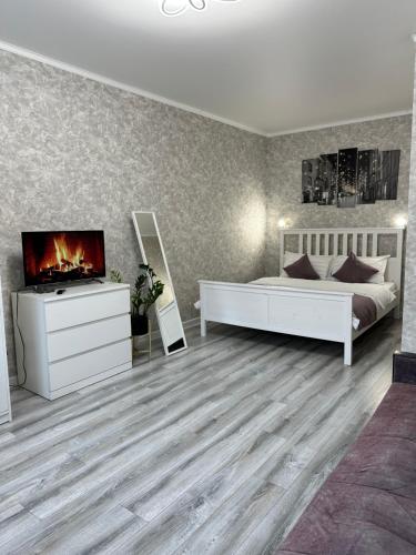 a bedroom with a bed and a tv and a fireplace at Уютная квартира ЖК Сказочный мир город Астана in Astana