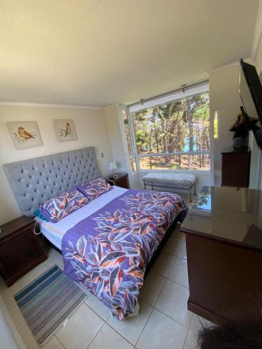 a bedroom with a bed and a large window at Espectacular departamento in Algarrobo