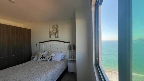a bedroom with a bed and a view of the ocean at Mar Laguna Hotel in Mazatlán