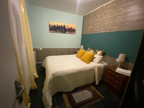 a bedroom with a large bed with yellow pillows at Casa kintsugi in Masquefa