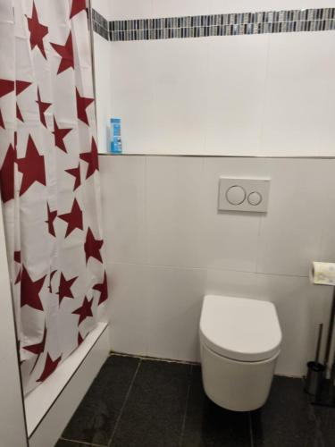 a bathroom with a toilet with red stars on the wall at Business Apartment in Kaiserslautern