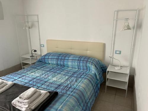 una camera con un letto con una coperta blu scozzese di Ca' Delle Erbe a Venezia
