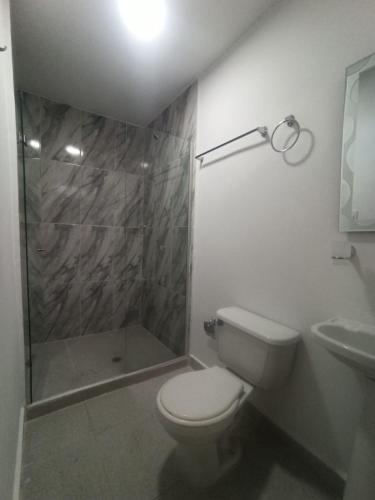 a bathroom with a shower and a toilet and a sink at CASA HOTEL YEMI in Barranquilla