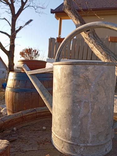 a metal bucket sitting next to two wooden barrels at Varázskuckó Apartman in Sümeg