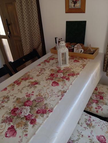 a bed with a floral bedspread with a lantern on it at Varázskuckó Apartman in Sümeg