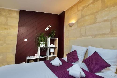 波爾多的住宿－Grand studio à Bordeaux chartrons，卧室配有一张带紫色枕头的大型白色床。