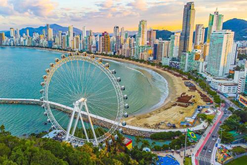 a city with a ferris wheel and a beach at Sacavem Flat Hotel Navegantes in Navegantes