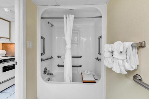 een badkamer met een douche en witte handdoeken bij Oceanfront Boardwalk Condo w Private Balcony and Beach in Myrtle Beach