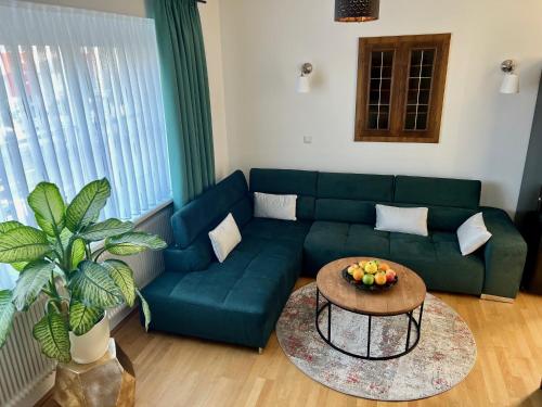 a living room with a green couch and a table at Hotel Genta in Salzburg