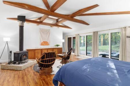 um quarto com uma cama e uma lareira em Modern Wooded Oasis with Hot Tub, WiFi, Deck, Grill & Dome! em Hedgesville